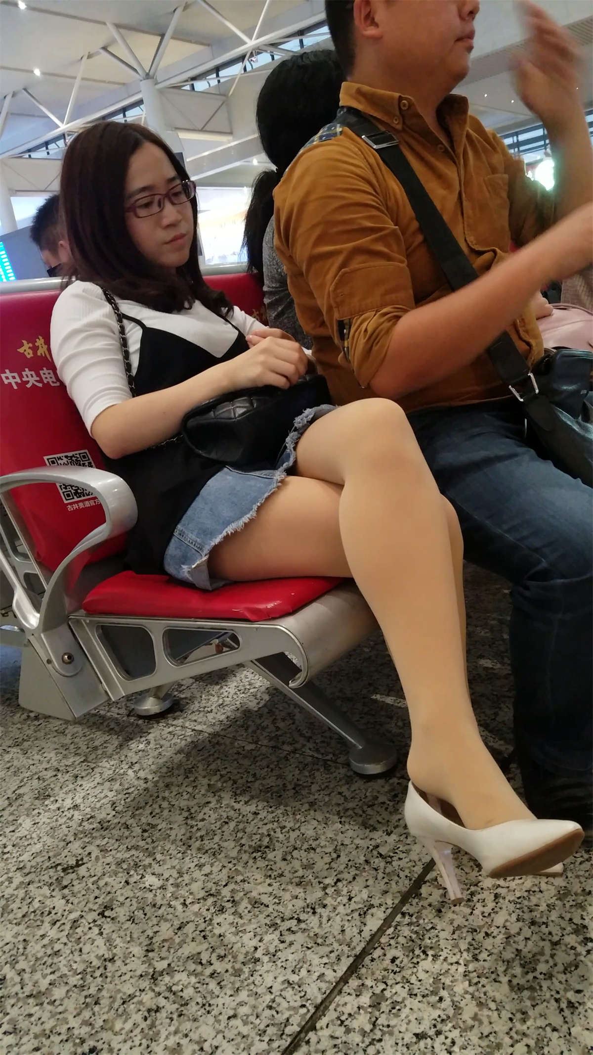 高铁站等车的白色高跟肉色丝袜牛仔短裙少妇