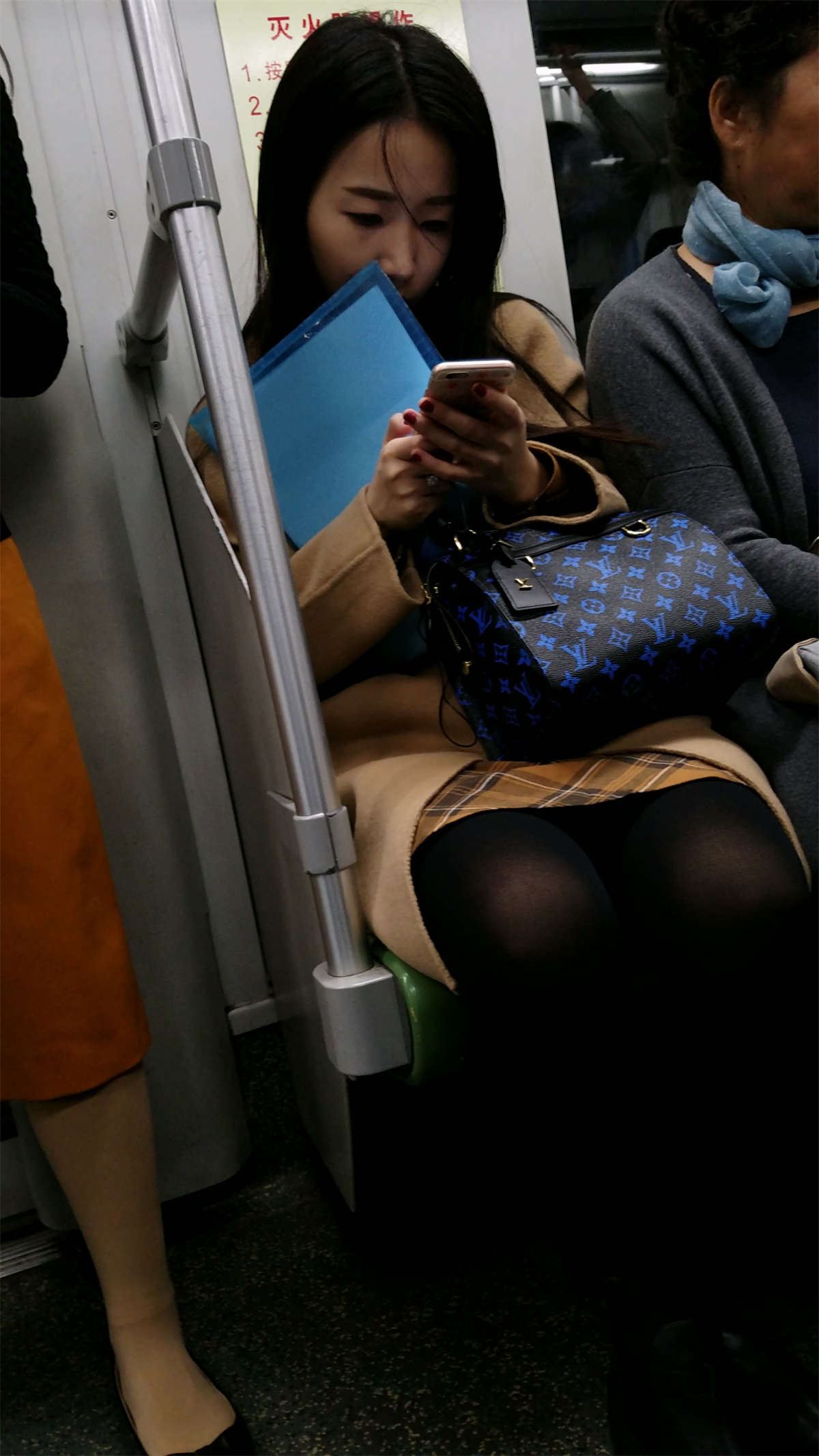 地铁玩手机的米色外套黑色丝袜OL美眉