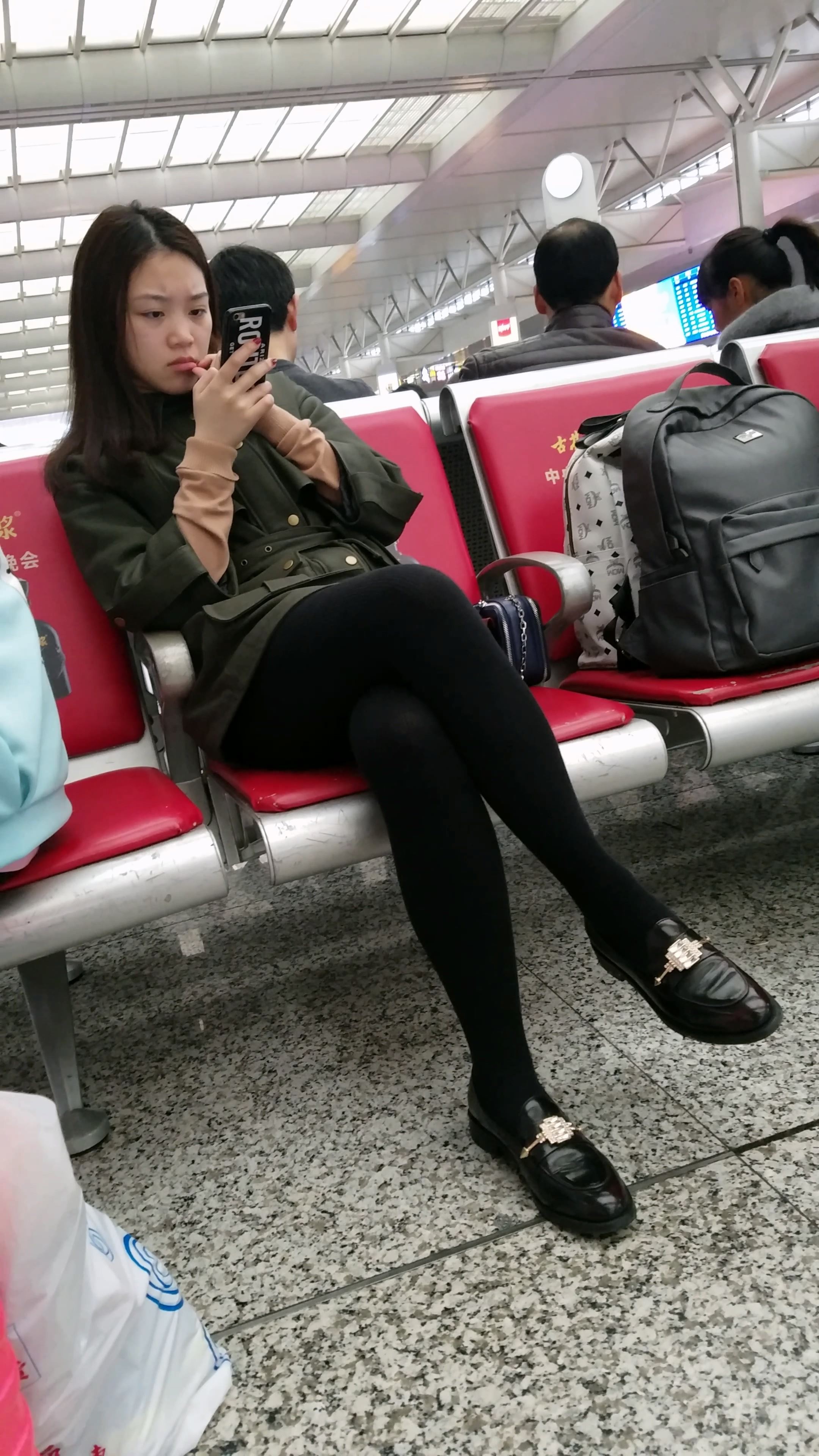 高铁站候车的黑色打底丝袜性感长腿美眉