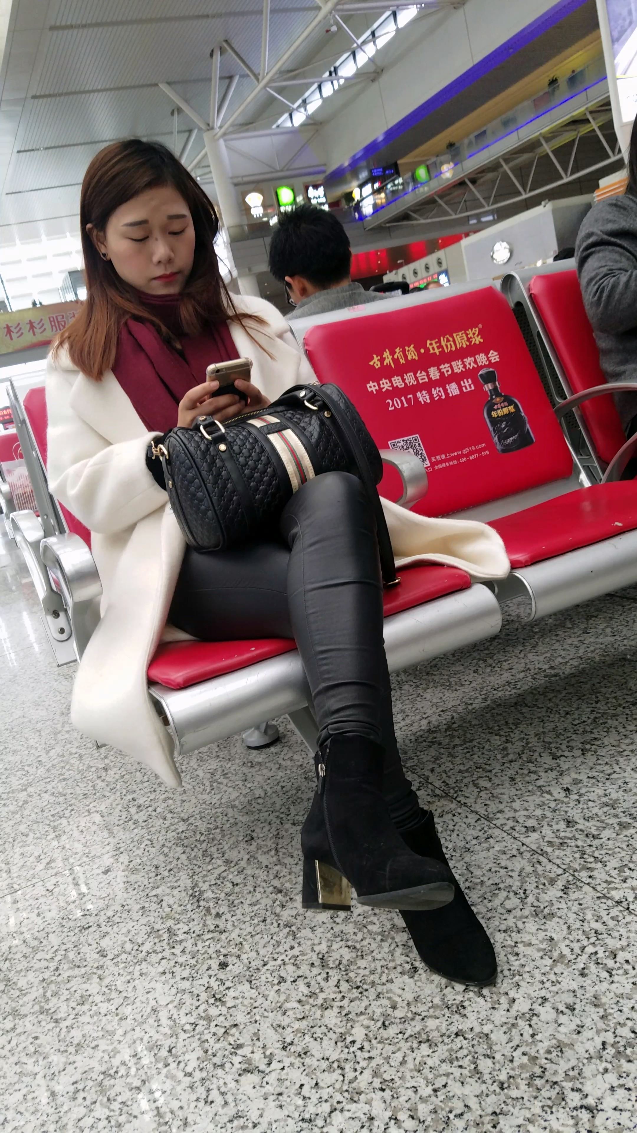 高铁站候车的黑色紧身皮裤长发少妇