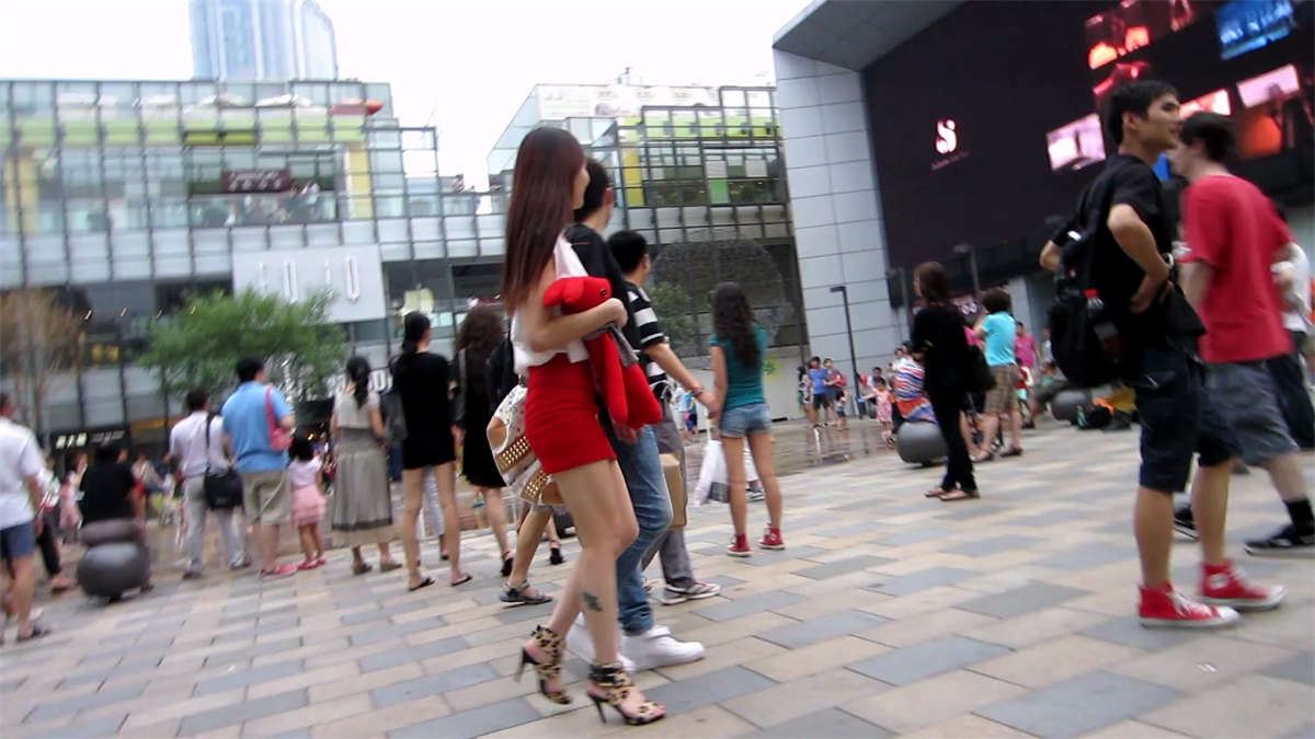 和男友一起逛街的青春靓丽红色包臀短裙美女