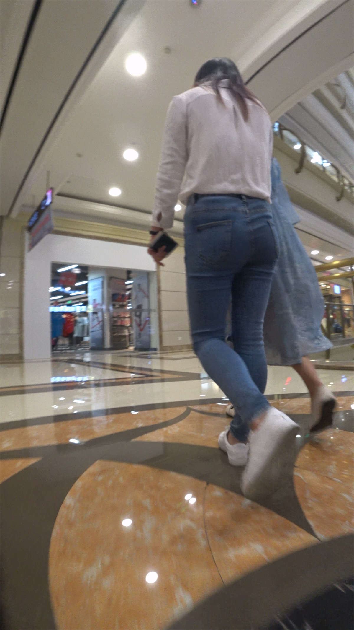 白衬衫紧身蓝色牛仔裤街拍美女跟姐妹逛商场