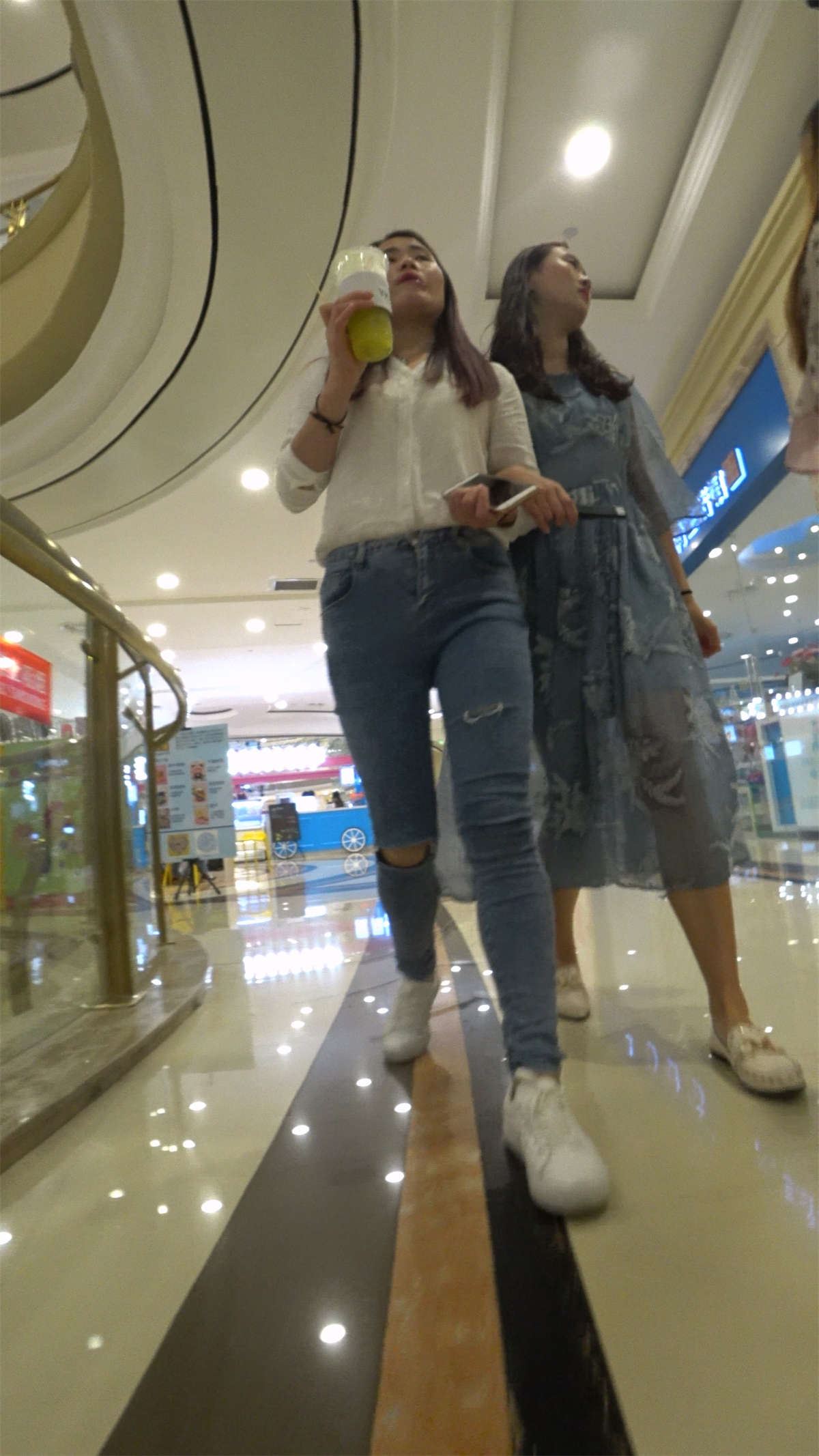 白衬衫紧身蓝色牛仔裤街拍美女跟姐妹逛商场