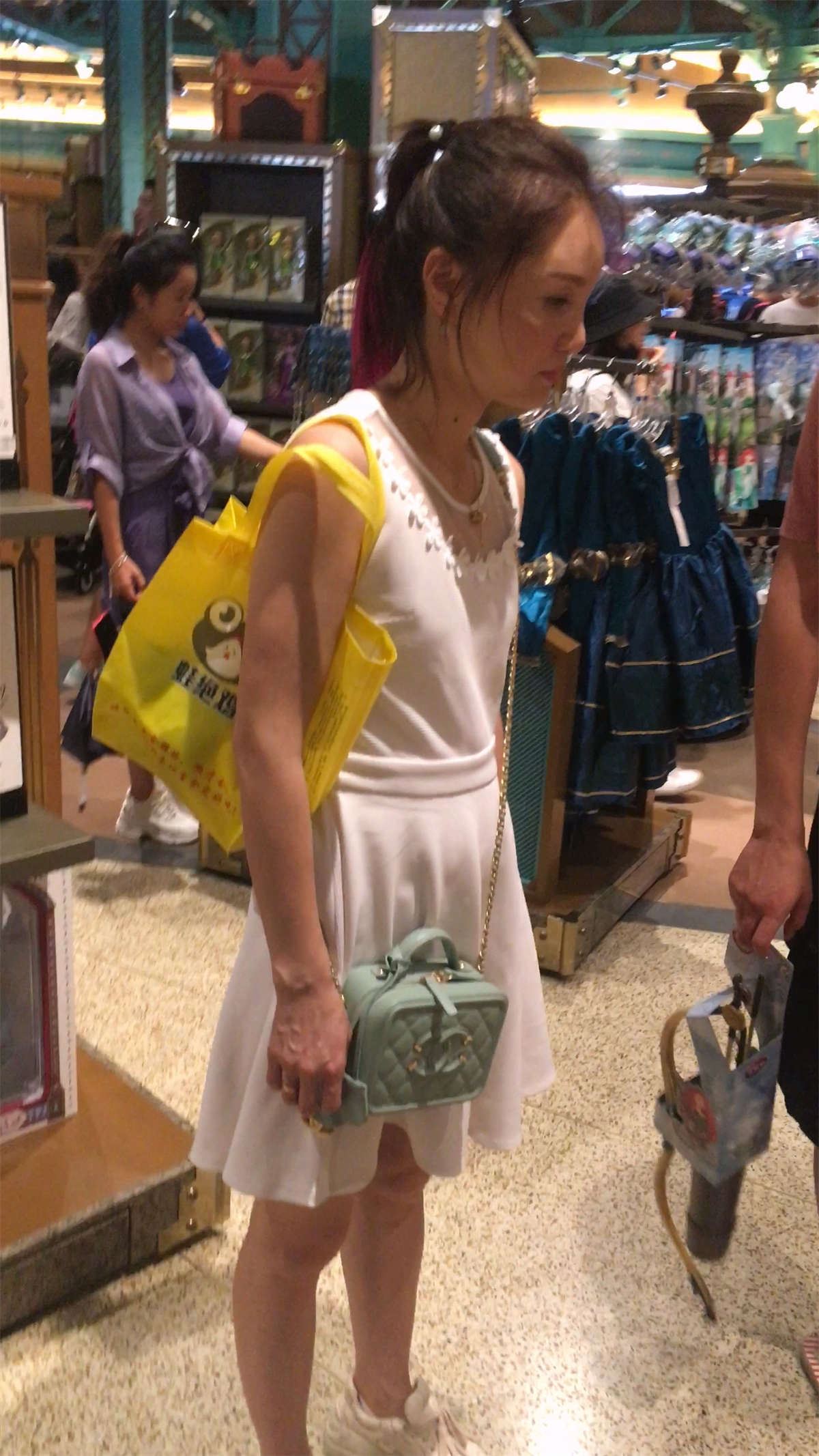 白色连衣裙少妇给女儿买洋娃娃