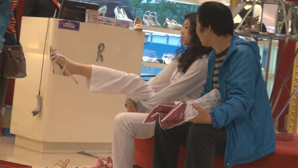 父母陪着买鞋的青春女孩，一双脚露的是毫无保留