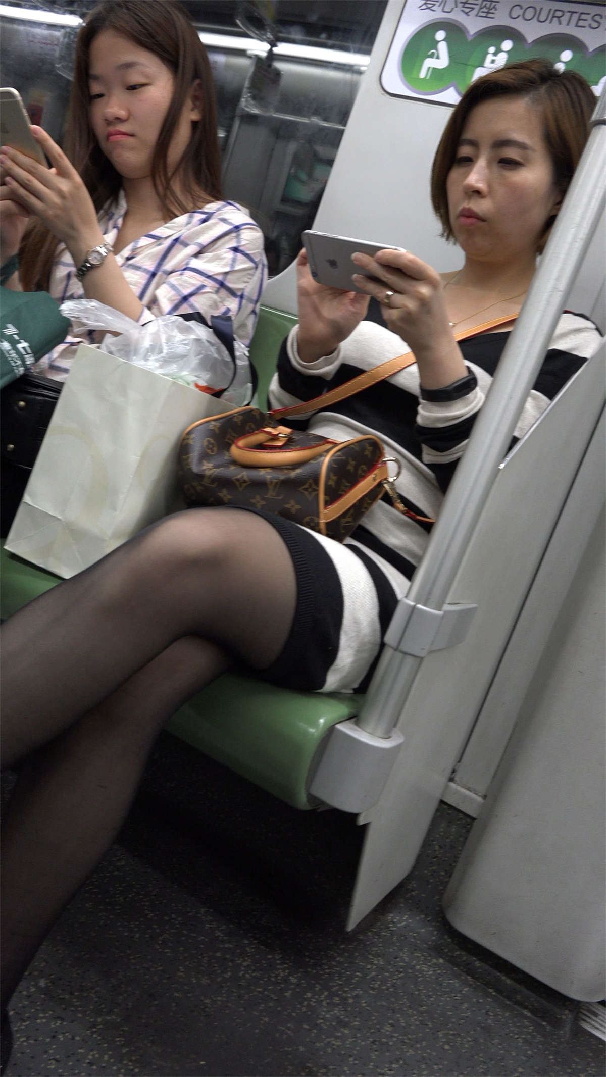 地铁上玩手机的黑丝美女