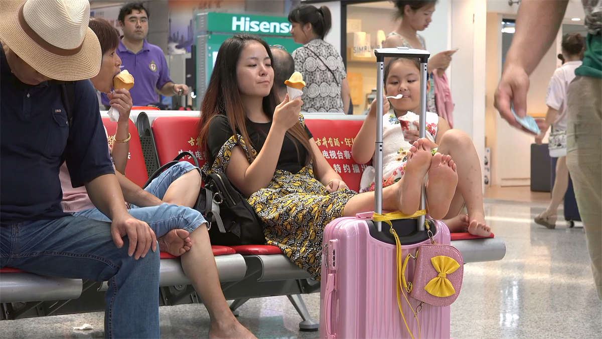 可爱型少妇双腿翘上行李箱，美甲足底露得毫不含糊