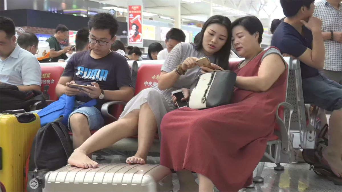 可爱的姑娘脚翘在行李箱上穿船袜