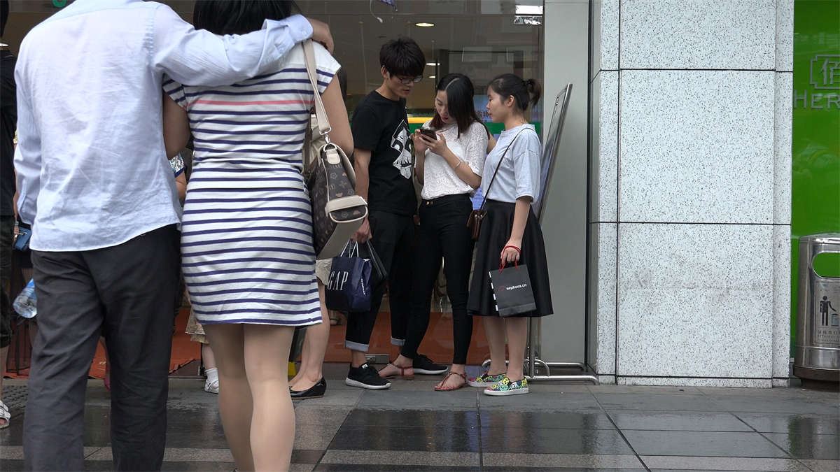 商场门口躲小雨的美女