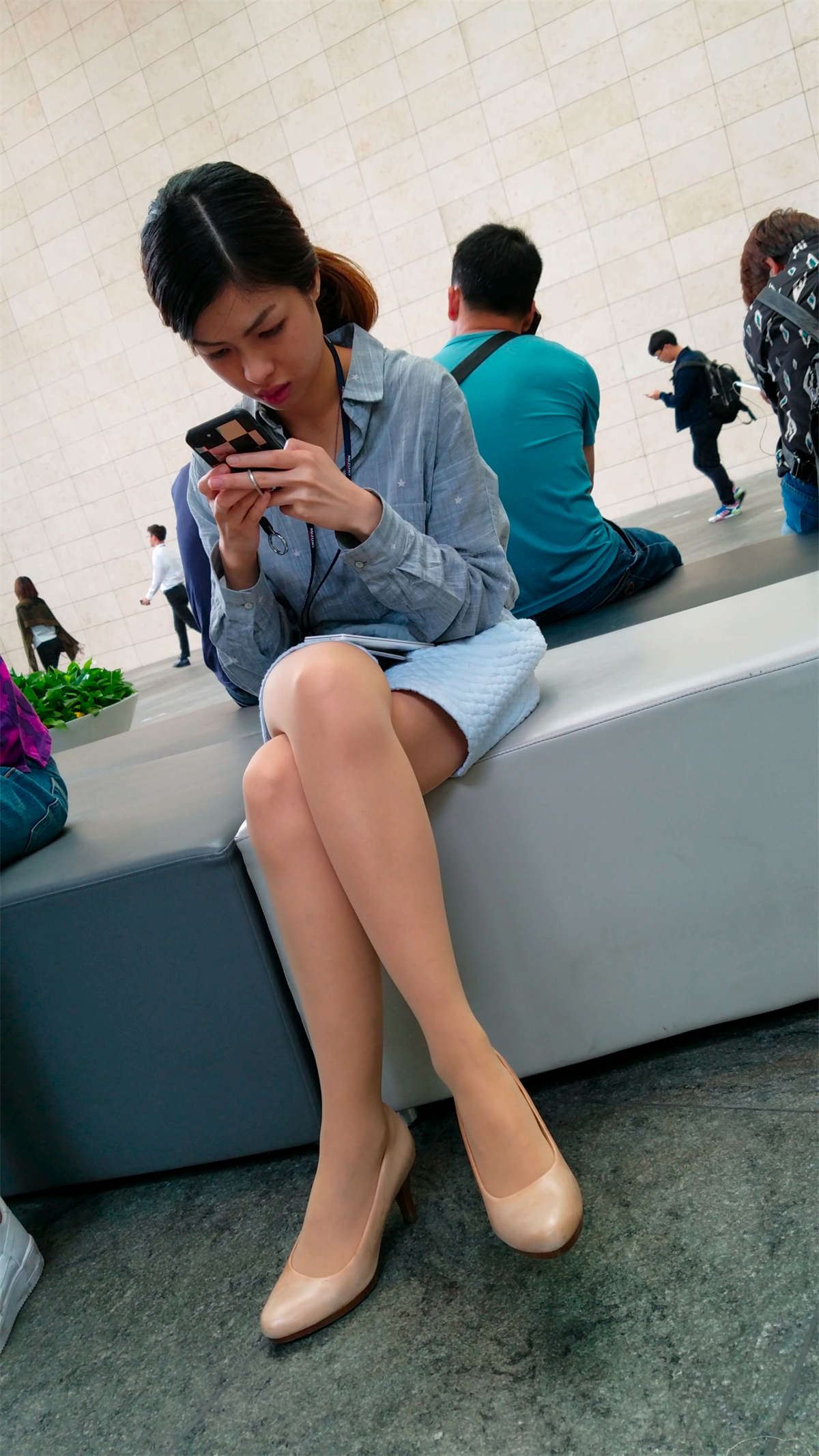 玩手机的蓝色短裙肉色丝袜高跟白腿OL妹子