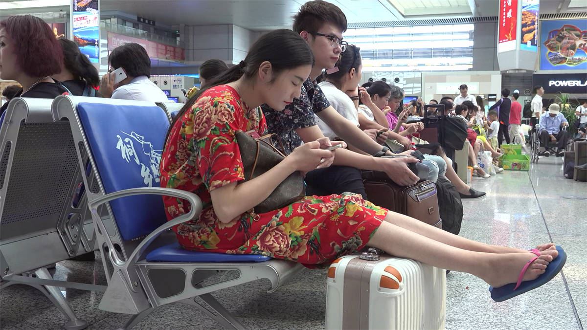 女孩素足修长纤细，一袭红衣花团锦簇应景节日