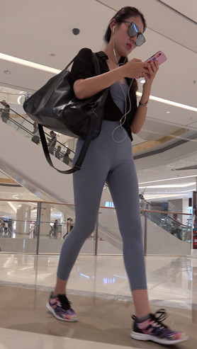商场里戴着墨镜的紧身裤美女