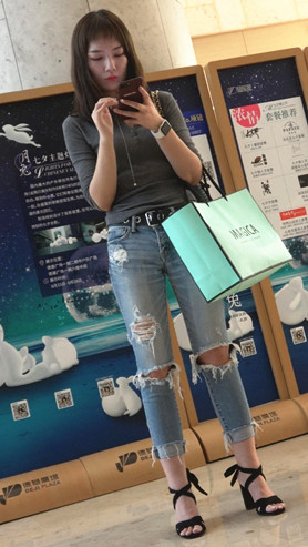 玩手机的破洞牛仔裤妹子