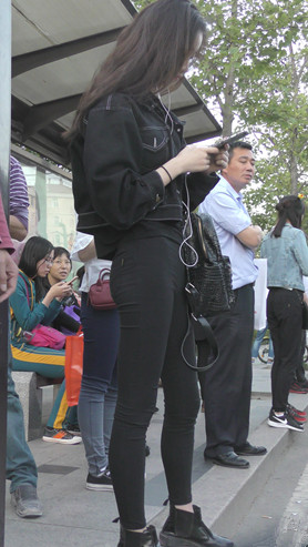 等车的黑衣牛仔裤美女
