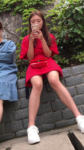 玩手机的红裙美女