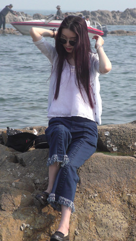 海边拍照的牛仔裤美女