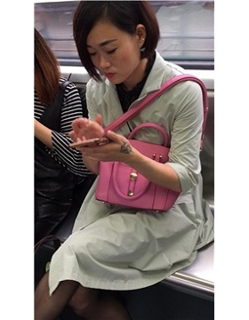 短发美女地铁上聊微信很投入