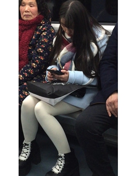 低头玩手机的白丝袜美腿可爱萌妹子。