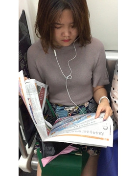 地铁上拍摄看报纸的美女，清纯甜美。