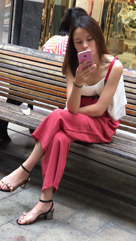 路边玩手机的小妹