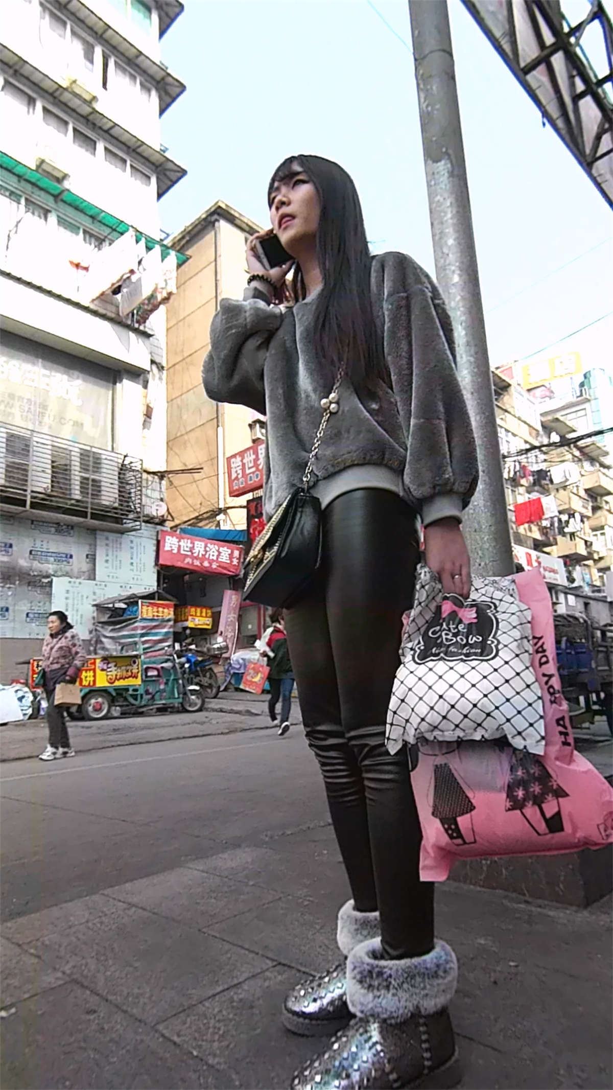 给闺蜜打电话的紧身皮裤美女