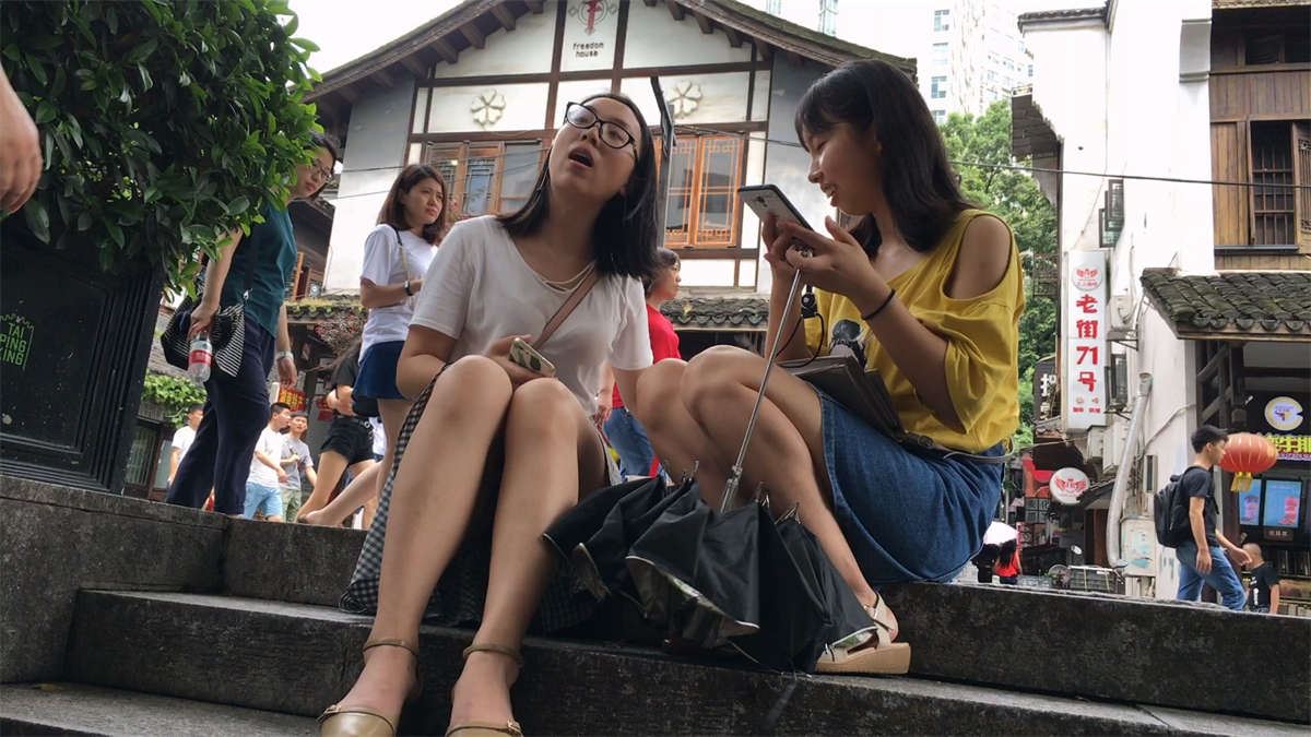 坐在台阶休息的两个美女
