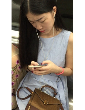 地铁拍摄低头玩手机的小清新美女