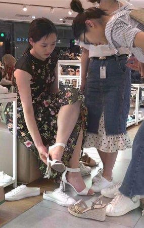 美脚女孩在鞋店试鞋子的场景