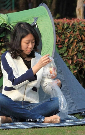 街拍草地上的白衣牛仔裤短袜美眉