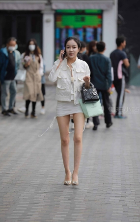 街拍打电话的短裙高跟美女