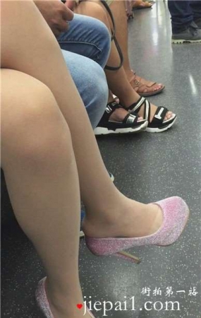 地铁上低头玩手机的女孩，一双高跟很抢眼。