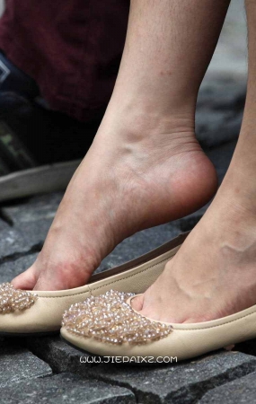 长椅上的漂亮女孩不自觉地把鞋脱了