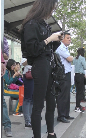 等车的黑衣牛仔裤美女