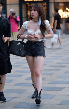 挎着包包的黑色热裤美女