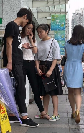 商场门口躲小雨的美女