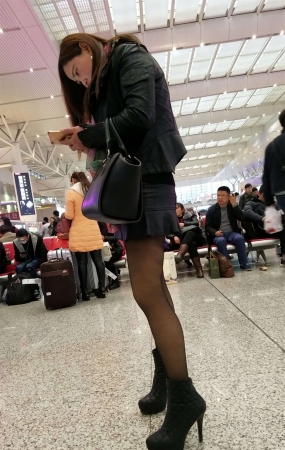 高铁站拍摄超短裙黑色丝袜高跟长发少妇