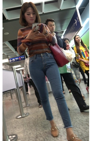 地铁站玩手机的牛仔裤小姐姐