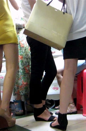 商场身材很棒的黄色包臀连衣裙细腰美女