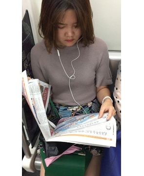 地铁上拍摄看报纸的美女，清纯甜美。