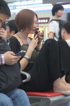 候车室的美女把脚放在板凳上
