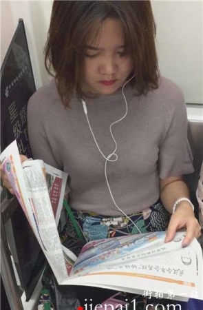 地铁上拍摄看报纸的美女，清纯甜美。