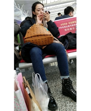 4k-高挑身材紧身蓝色牛仔裤美眉候车室玩手机。