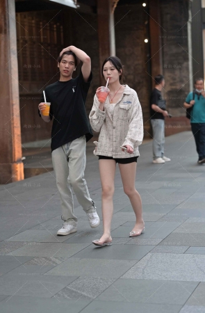街拍手拿果汁饮料的美腿小姐姐