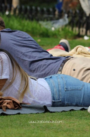 街拍平卧草地上的长发牛仔妹子