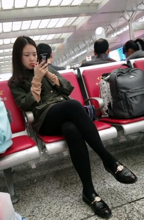 高铁站候车的黑色打底丝袜性感长腿美眉