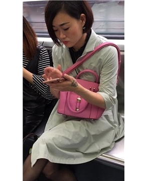 短发美女地铁上聊微信很投入