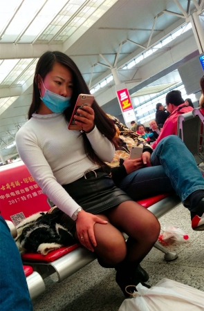 高铁站候车的黑色紧绷包臀皮裙黑丝长发少妇