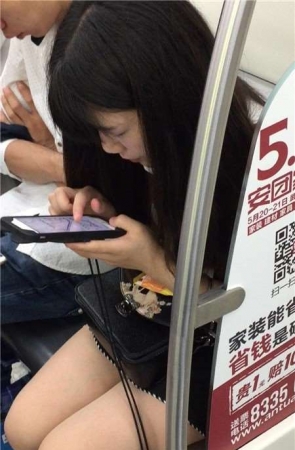 地铁上专心玩手机的美腿小清纯美女