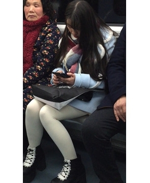 低头玩手机的白丝袜美腿可爱萌妹子。