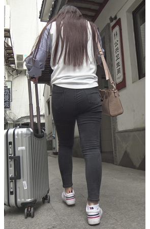 推着行李箱的黑色紧身牛仔裤女孩